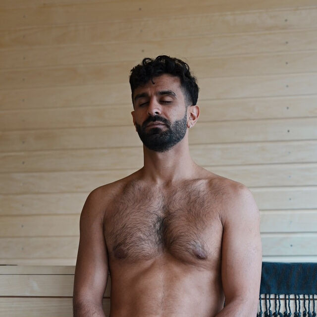 Gæst sidder med lukkede øjne på saunabænken hos HotSpot Sauna