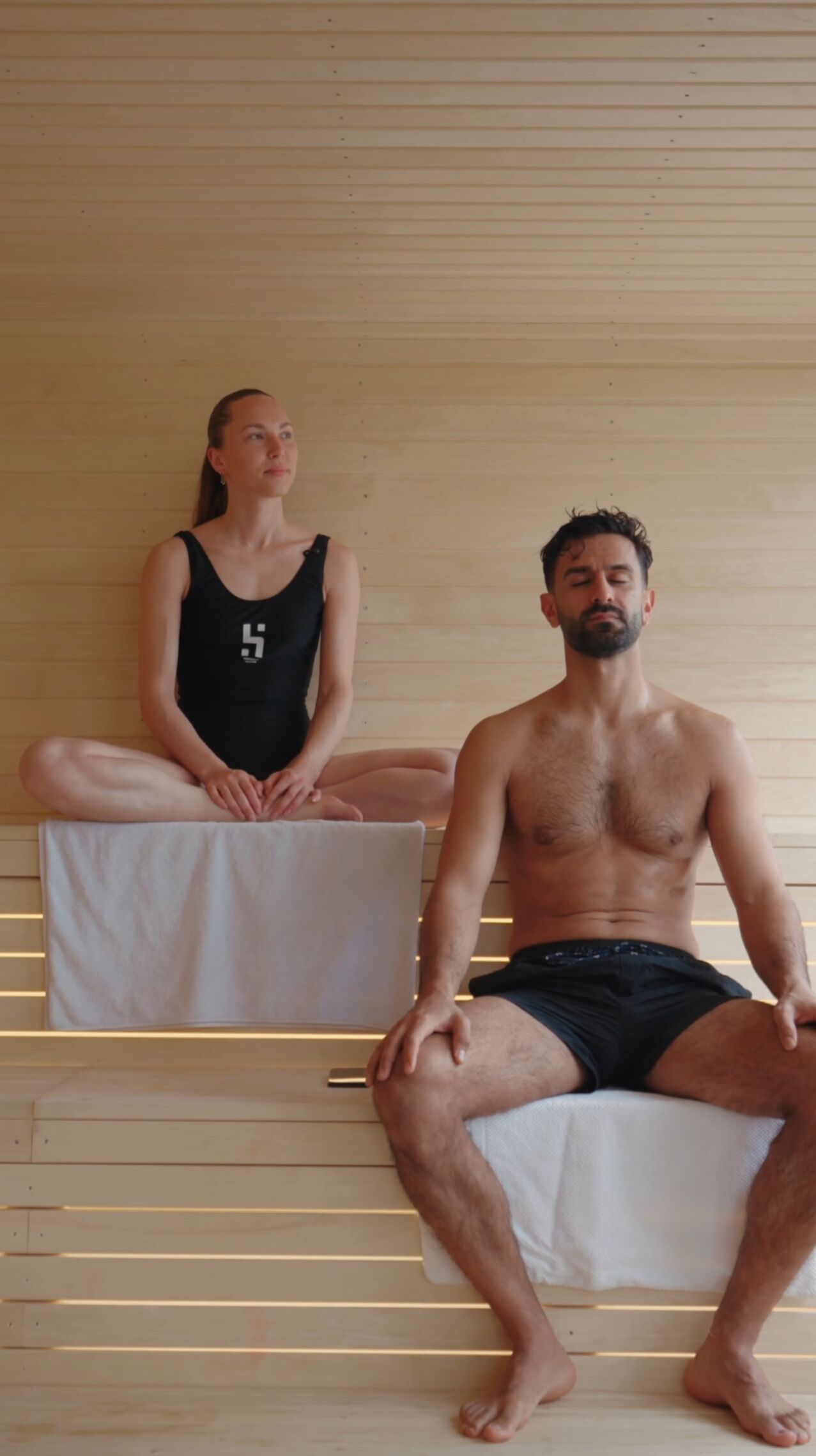 To gæster sidder i stilhed på saunabænken hos HotSpot Sauna